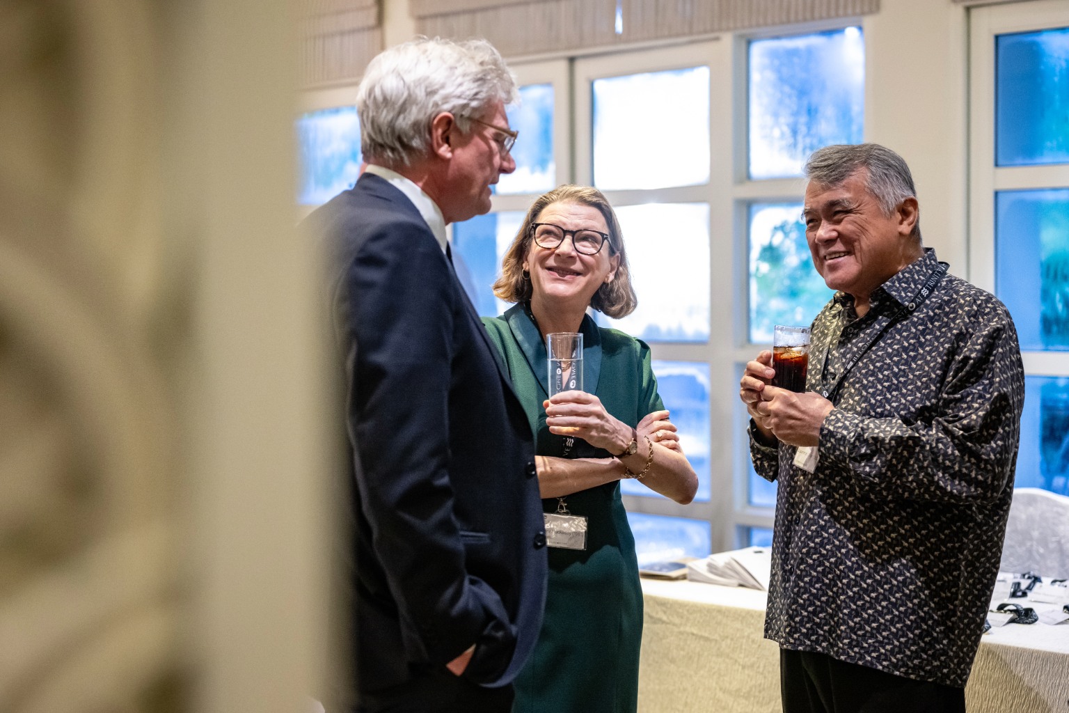 Alumnus speaking with Mary Hockaday and Tim Harvey-Samuel at Trinity Hall's Anniversary drinks in Singapore.