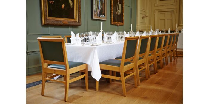 Colour photo of the Dining Hall with a long table set for a formal dinner.