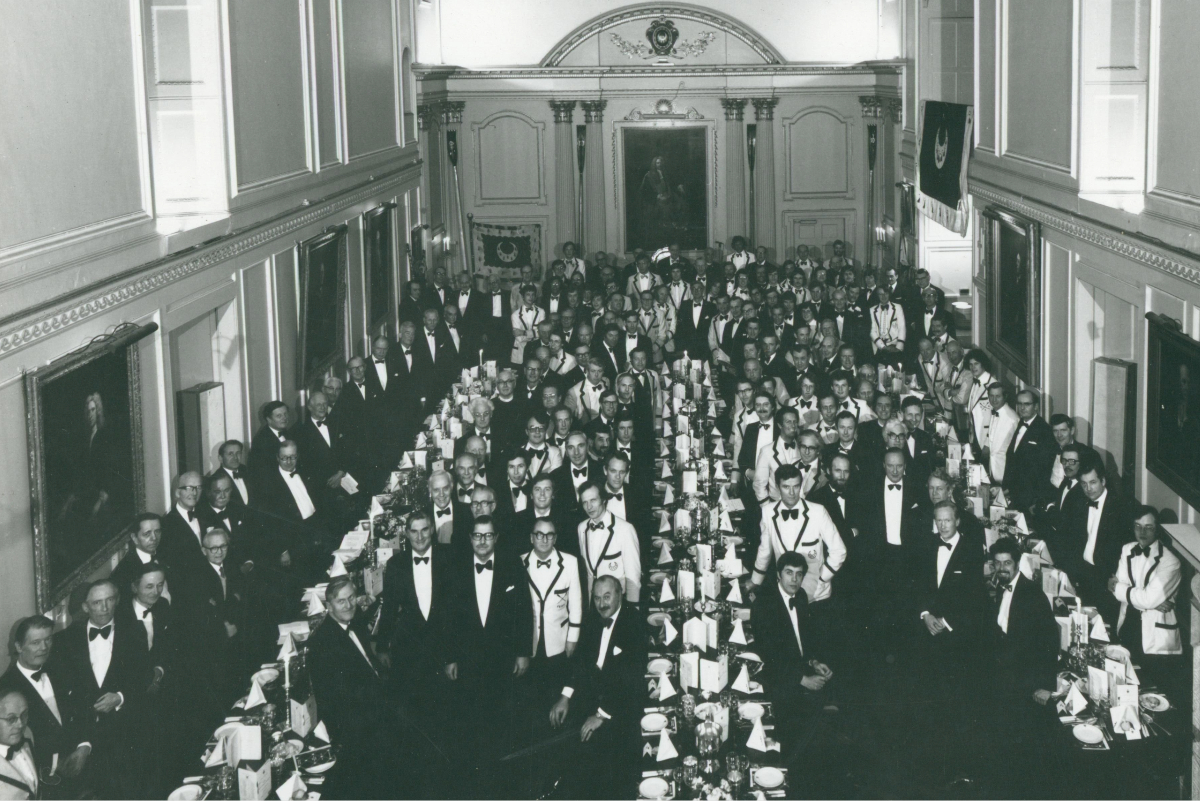 Attendees standing for a group photo in the Dining Hall at the 150th Anniversary of the Boat Club.