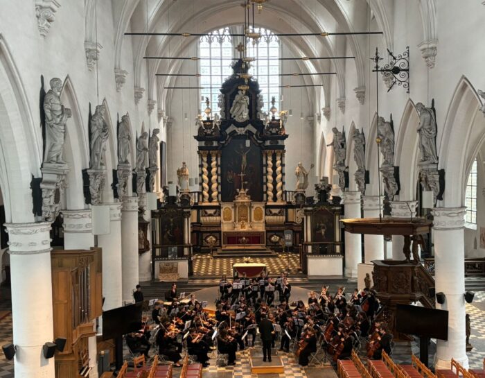 Colour photo of the interior of a church with an orchestra performing.