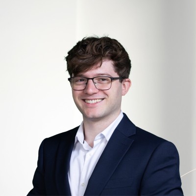 Colour portrait of a young man smiling at the camera.